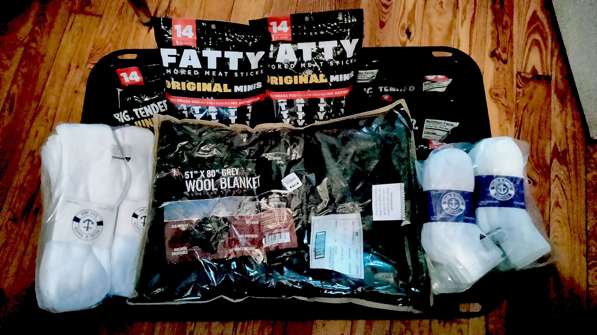 A gift basket containing socks, blankets, and care packages